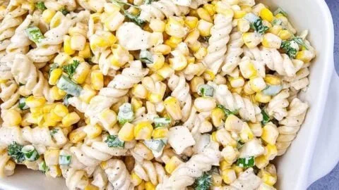 Bowl of Mexican street corn pasta salad topped with fresh cilantro and lime