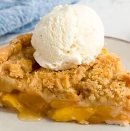 Delicious peach crumble dessert topped with golden brown crumble topping.