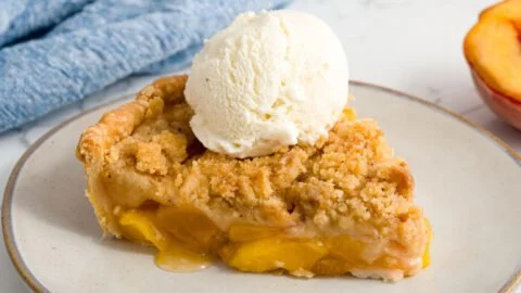 Delicious peach crumble dessert topped with golden brown crumble topping.