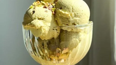 Bowl of pistachio cottage cheese ice cream sprinkled with chopped nuts