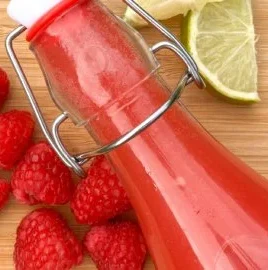 Raspberry Lime Probiotic Soda in a glass with vibrant colors and bubbles.