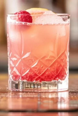 Refreshing Raspberry Vodka Sour cocktail with vibrant red color and garnished.