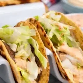 Delicious Smash Burger Tacos topped with special sauce served on a plate.