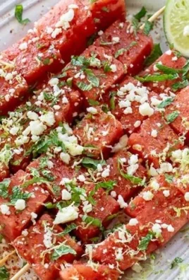 Colorful watermelon skewers seasoned with Tajin, perfect for summer snacking.