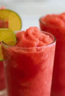 Refreshing watermelon slushie in a glass with ice and mint leaves