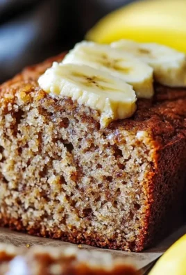Homemade moist banana bread sliced on a wooden board