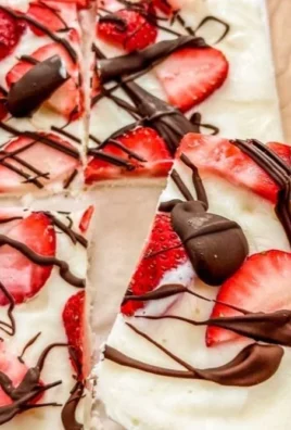 Fresh strawberry yogurt bark drizzled with dark chocolate on a plate