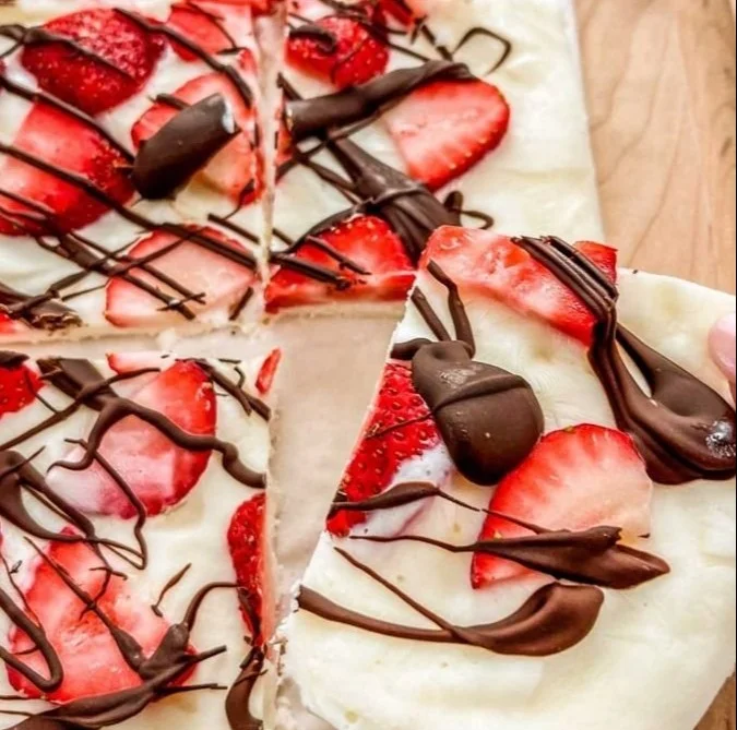 Fresh strawberry yogurt bark drizzled with dark chocolate on a plate