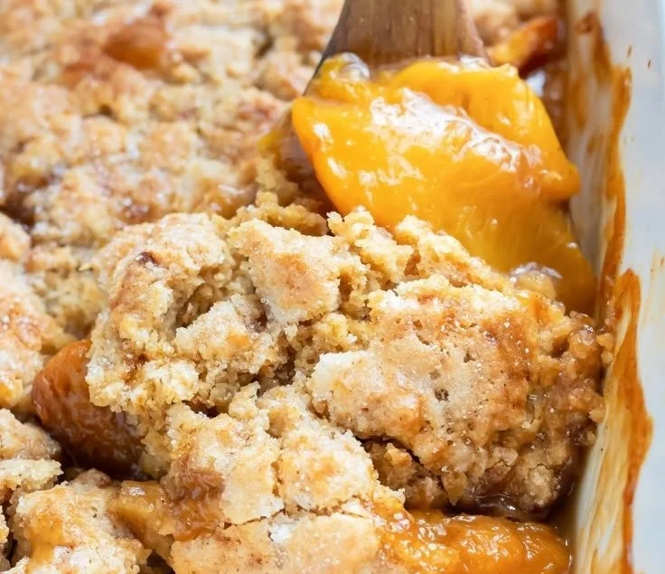 Delicious gluten-free peach cobbler topped with a golden crust and fresh peaches