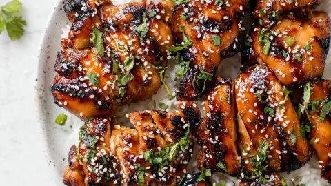 Delicious grilled Asian chicken served with vibrant vegetables and sauce.