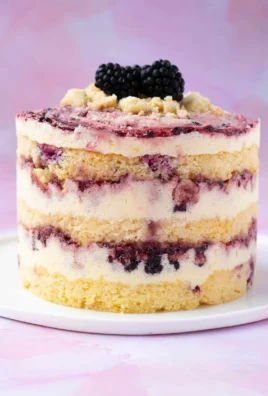 Delicious Lemon Blackberry Cake with fresh lemons and blackberries on top.