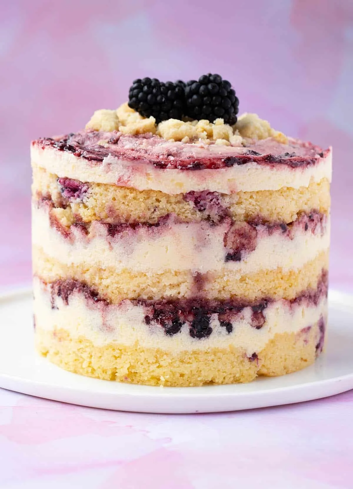 Delicious Lemon Blackberry Cake with fresh lemons and blackberries on top.