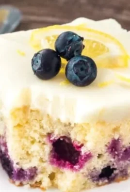 Delicious lemon blueberry cake topped with fresh blueberries and lemon zest.