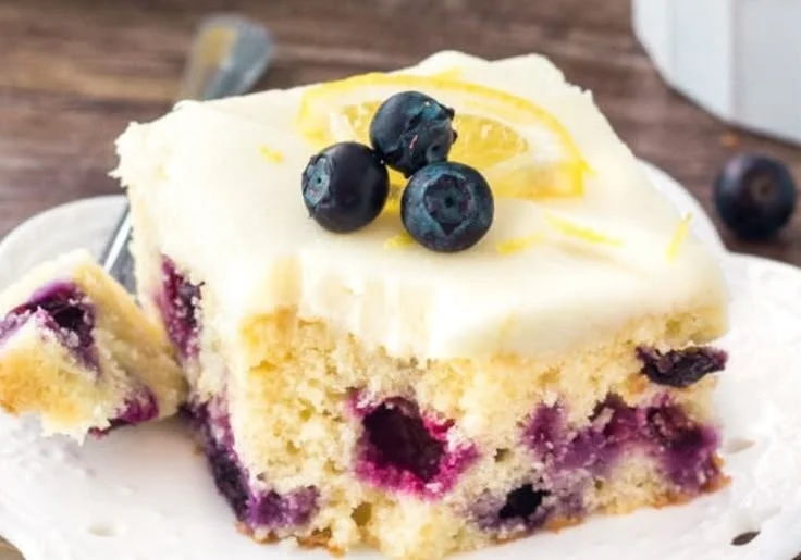 Delicious lemon blueberry cake topped with fresh blueberries and lemon zest.