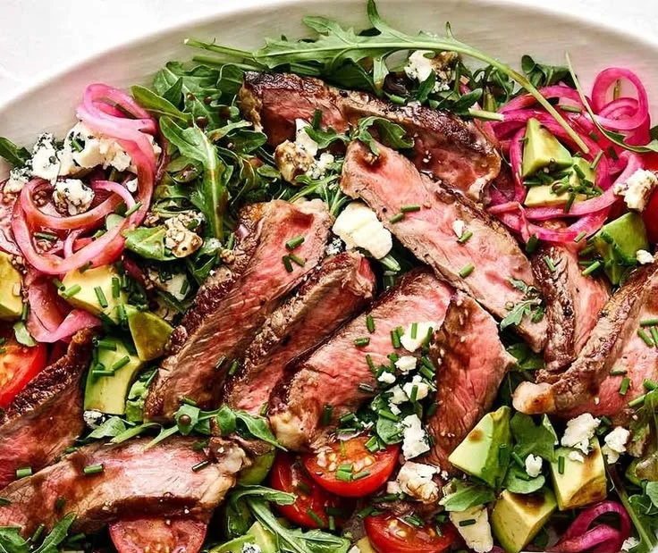 Steak Salad with Arugula and Blue Cheese garnished with fresh ingredients