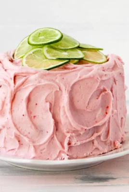 Slice of delicious Strawberry Limeade Cake topped with fresh strawberries