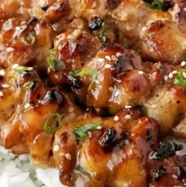 Delicious teriyaki chicken skewers on a grill, garnished with green onions.